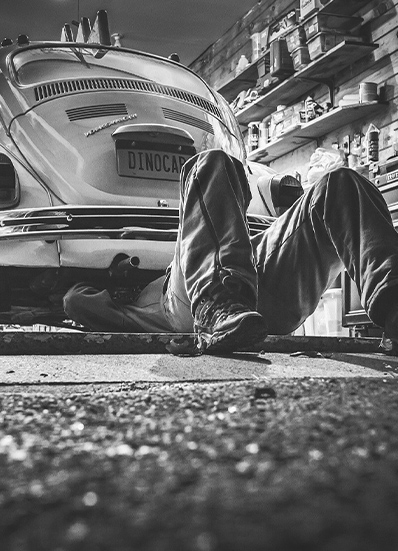 homme qui bricole voiture garage